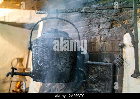 bouilloire vintage dans la fumée de la cheminée dans le vieux pub anglais, Royaume-Uni Banque D'Images