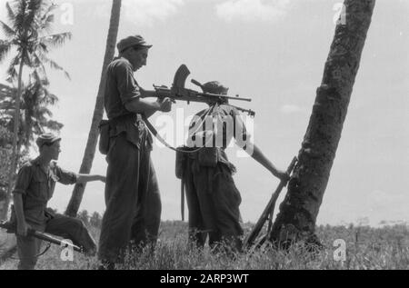 2-15 Regiment Infantry et I-12 RVA à l'avance East Java Trois soldats néerlandais au cours d'une action. Le gingembre pointe son arme et utilise l'épaule d'un autre militaire comme aide à la stabilisation Date: 20 décembre 1948 lieu: Indonésie, Antilles néerlandaises de l'est Banque D'Images