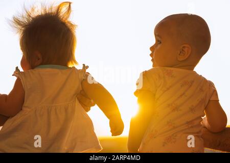 deux petites filles qui contemplent le coucher du soleil sur le balcon. Banque D'Images