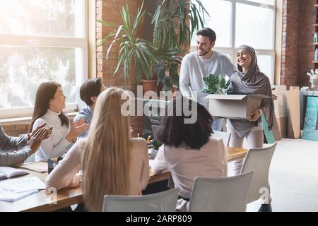 Jeune équipe d'affaires multiraciale accueillant une nouvelle femme dans le hijab Banque D'Images