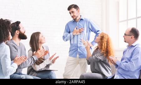 Jeune homme appréciant le soutien à la séance de thérapie de groupe à réadaptation Banque D'Images