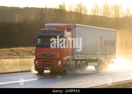 Red Volvo FH 440 Pakkalan Liikenne Oy tire la remorque cargo DB Schenker le long de la route humide dans la lumière dorée du coucher du soleil. Salo, Finlande. 24 Janvier 2020 Banque D'Images