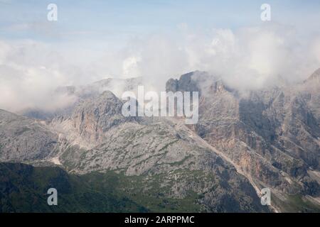 Cloud streaming au-dessus des falaises du groupe Rosengarten vue sur les pentes du Plattkofel Val Gardena Dolomites Tyrol du Sud Italie Banque D'Images