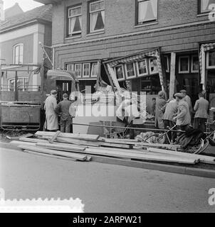 Sturcked, parce qu'il a soudainement vu une voiture de passager venant de la droite, le conducteur d'un camion dans la Dorpsstraat à Heerde a jeté la roue à gauche, a frappé un trottoir et a perdu la puissance sur la roue. Le camion de 17 tonnes a été chargé dans un magasin de matériel et de produits ménagers. Personne du magasin n'a été blessé. Le chauffeur de 32 ans est sorti avec la droite. Son cochauffeur a cassé les deux jambes Date: 5 avril 1957 lieu: Gueldre, Heerde mots clés: Accidents, circulation, camions, magasins Banque D'Images