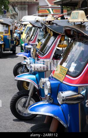 Taxi thaïlandais Tuk Tuk en chrome coloré trois motos à roues attendent devant le Grand Palace en Thaïlande pour prendre les voyageurs et les touristes dans Ba en plein centre Banque D'Images