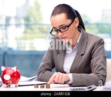 Le failli a businesswoman with piggy bank Banque D'Images