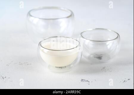 Bol en verre de lait avec verrerie vide sur table en bois Banque D'Images