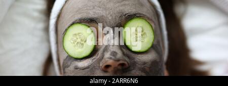 Femme fait le masque facial à l'argile gris accueil Banque D'Images