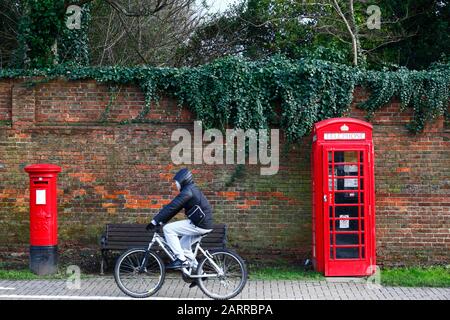 La personne qui fait du vélo à l'ancienne boîte postale et boîte de téléphone, Tonbridge, Kent, Angleterre Banque D'Images