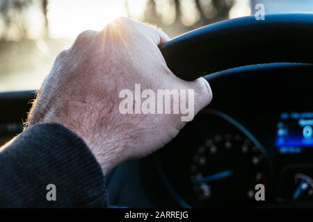 Une main mâle sur le volant d'une voiture Banque D'Images