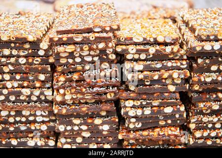 Une pile de barres cassantes d'arachide couvertes de graines de sésame à vendre sur un marché aux Visayas, Philippines Banque D'Images