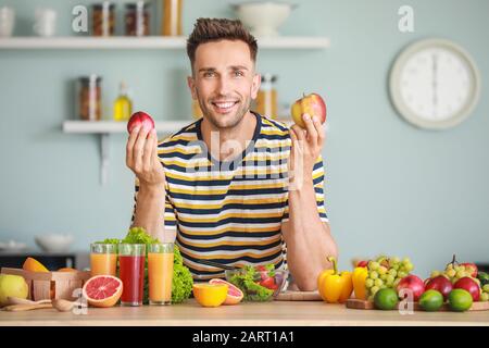 Beau homme avec des produits sains dans la cuisine. Concept de perte de poids Banque D'Images