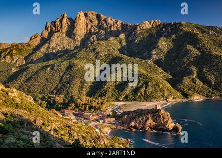 Massif du Capo d'Orto au-dessus de la ville de Porto, Tour de Porto, tour de défense génoise, sur Golfe de Porto au coucher du soleil, Corse-du-Sud, Corse, France Banque D'Images