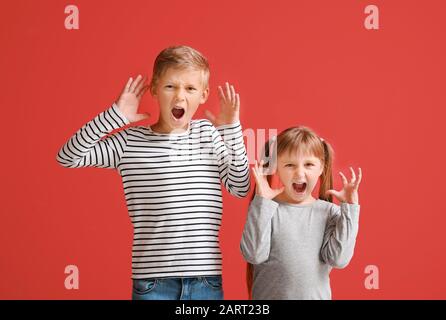 Portrait de petits enfants en colère sur fond couleur Banque D'Images