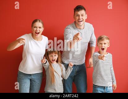 Portrait de la famille en colère sur fond couleur Banque D'Images