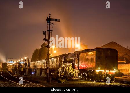 Tir d'exposition prolongée, locomotive à vapeur britannique 60163 Tornado sur la ligne ferroviaire du patrimoine de Severn Valley la nuit, dans le noir; l'équipage à vapeur se prépare au départ. Banque D'Images