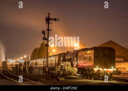 Tir d'exposition prolongée, locomotive à vapeur britannique 60163 Tornado sur la ligne ferroviaire du patrimoine de Severn Valley la nuit, dans le noir; l'équipage à vapeur se prépare au départ. Banque D'Images