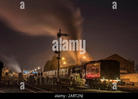 Tir d'exposition prolongée, locomotive à vapeur britannique 60163 Tornado sur la ligne ferroviaire du patrimoine de Severn Valley la nuit, dans le noir; l'équipage à vapeur se prépare au départ. Banque D'Images