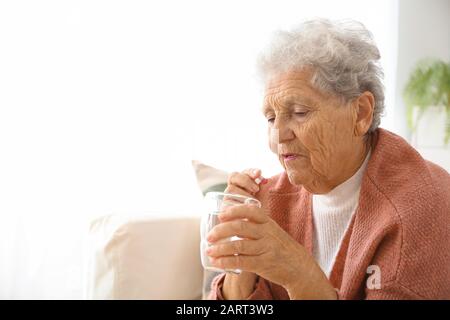 Femme âgée prenant des médicaments à la maison Banque D'Images