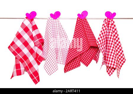 Serviettes de bain isolées. Gros plan de diverses serviettes de cuisine à damier rouge avec des clous de girofles violettes pendent sur un rail de vêtements isolé sur un fond blanc Banque D'Images