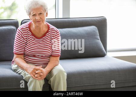 Femme senior souffrant de douleur au genou à la maison Banque D'Images