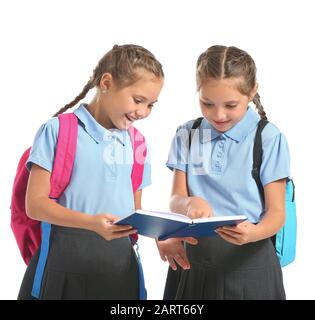 Portrait de filles jumelles avec sacs scolaires et livre sur fond blanc Banque D'Images