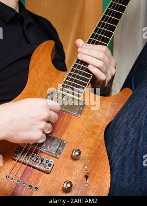 Musicien jouant de la guitare électrique en bois Banque D'Images