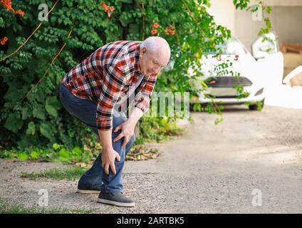 Homme senior souffrant de douleur dans les jambes à l'extérieur Banque D'Images