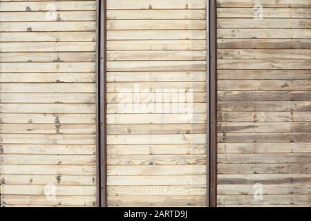 Fond de texture en bois avec planches horizontales et barres métalliques verticales à la lumière du soleil Banque D'Images