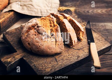 Pain de seigle rustique maison avec graines de coriandre sur planche à découper en bois. La nourriture rurale reste la vie. Banque D'Images