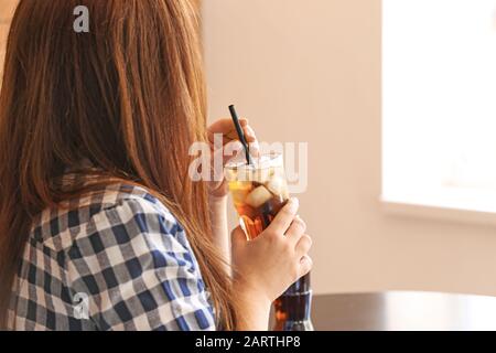 Femme buvant du cola froid dans le café Banque D'Images
