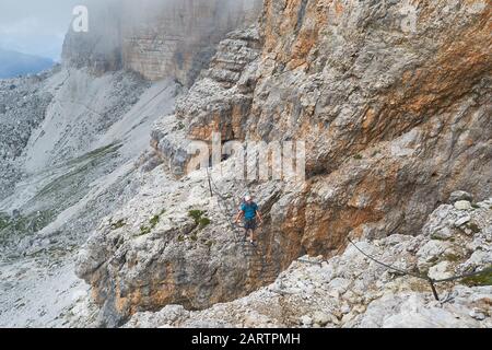 En traversant un pont suspendu sur la via ferrata Cesare Piazzetta, sur le chemin jusqu'au pic de Piz Boe, lors d'une excursion d'été dans les Dolomites m Banque D'Images