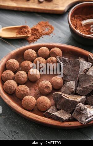 Assiette avec de délicieuses truffes douces et du chocolat sur table Banque D'Images