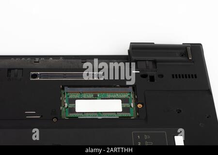 Gros plan du module de mémoire de l'ordinateur portable sur le logement de la carte mère. Sous l'ordinateur portable sur fond blanc, l'ordinateur portable a été produit en 2003. Banque D'Images