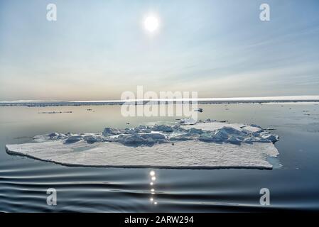 Flotteurs de glace et réflexion solaire dans l'océan Arctique au nord de Svalbard, Norvège Banque D'Images