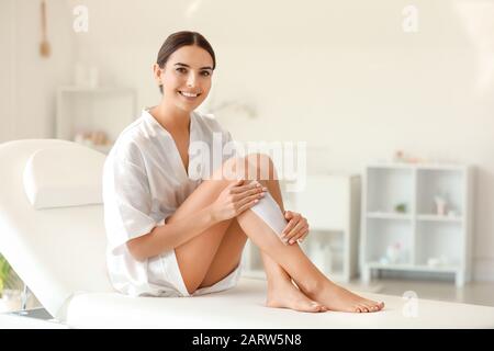 Belle jeune femme épilation des jambes à l'intérieur Banque D'Images