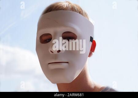 Mummery. Un homme dans un masque blanc. En arrière-plan un ciel ensoleillé. Banque D'Images