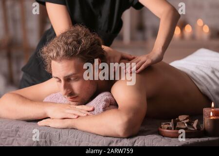 Jeune homme recevant un massage dans le salon de spa Banque D'Images