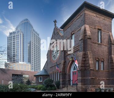 Charlotte, NC, USA-26 JAN 2020: À Tryon et W. 7ème rue, l'église épiscopale Saint-Pierre contraste avec un gratte-ciel moderne. Banque D'Images