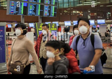 Une famille a vu porter des masques de protection en 95 pendant qu'ils marchent autour de l'aéroport de Changi à Singapour.Beaucoup de gens ont commencé à porter des masques de protection dans de nombreux endroits du monde en raison de la peur de l'éclosion de coronovirus Wuhan. Dix personnes ont été testées positives pour le coronavirus de Wuhan à Singapour le 29 janvier 2020, comme l'a indiqué le Ministère de la santé du pays. Banque D'Images