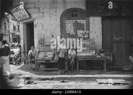 Photo Reportage Palembangs Street vendeurs dans un bâtiment d'angle dans le quartier chinois de PalembangAnnotation: Dans le bâtiment d'angle est un opticien situé Date: Janvier 1947 lieu: Indonésie, Hollandais East Indies, Palembangs, Sumatra Banque D'Images