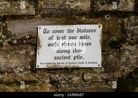 Signe dans les ruines du château de Newark, "pour couvrir la distance de seulement un mile, marcher onze fois le long de cette ancienne pile", Newark on Trent, Notinghamshire, Banque D'Images