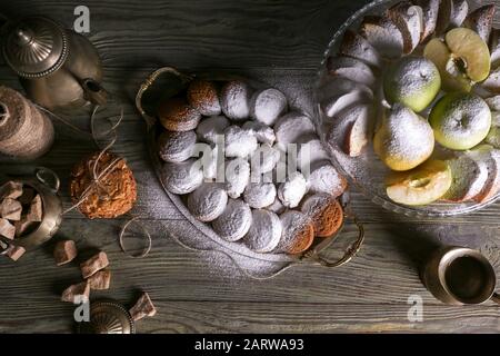 Plateau avec biscuits savoureux, fruits frais et poudre de sucre sur table en bois Banque D'Images