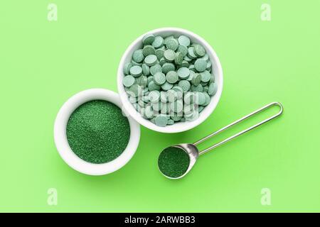 Composition avec de la poudre de spiruline et des pilules sur fond de couleur Banque D'Images