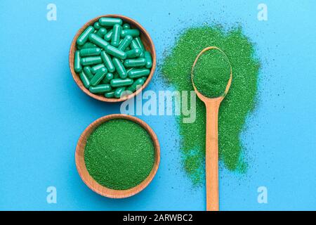 Composition avec de la poudre de spiruline et des pilules sur fond de couleur Banque D'Images