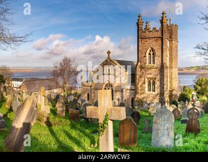 Le soleil de l'après-midi frappe les pierres tombales anciennes dans la cour de l'église St Mary's, Appledore, North Devon. Banque D'Images