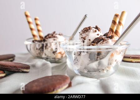 Bol avec glace savoureuse et biscuits au chocolat sur table Banque D'Images