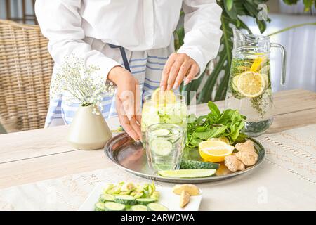 Femme préparant de l'eau infusée saine Banque D'Images