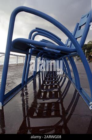 Photo verticale des chaises bleues se reflétant sur le sol à la plage Banque D'Images