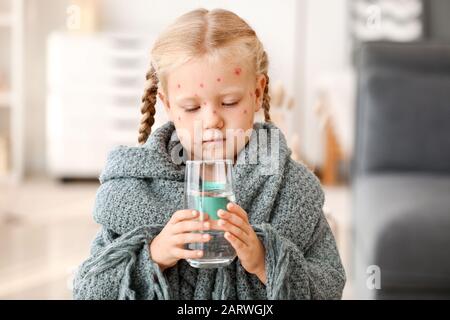 Petite fille malade avec l'eau potable de la varicelle à la maison Banque D'Images